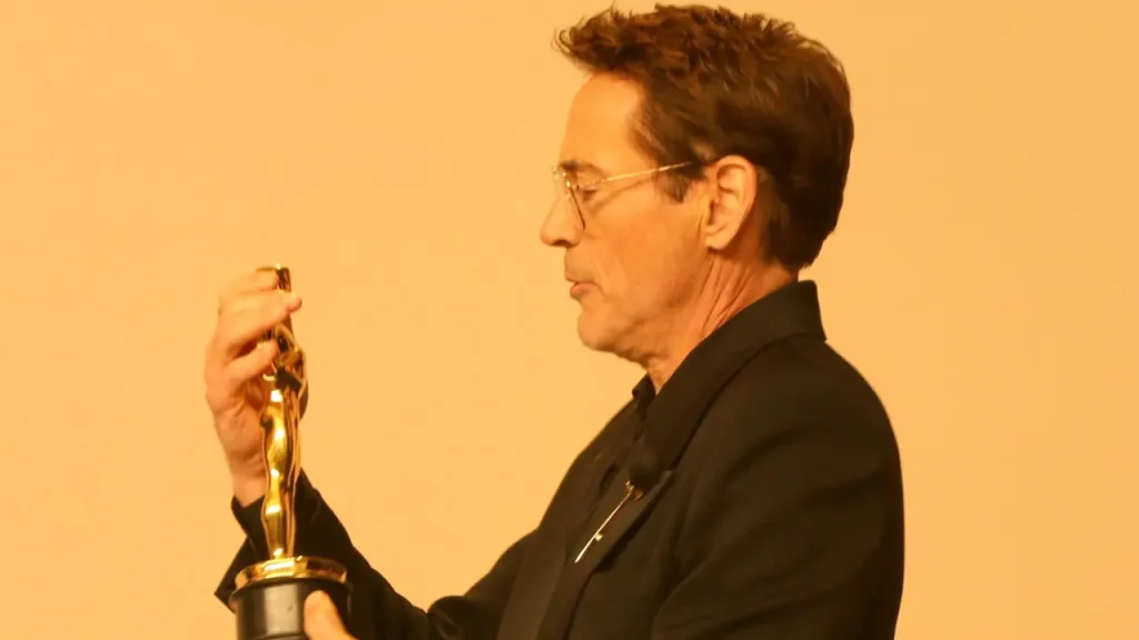 Robert Downey Jr guarda l'Oscar che ha vinto per Oppenheimer