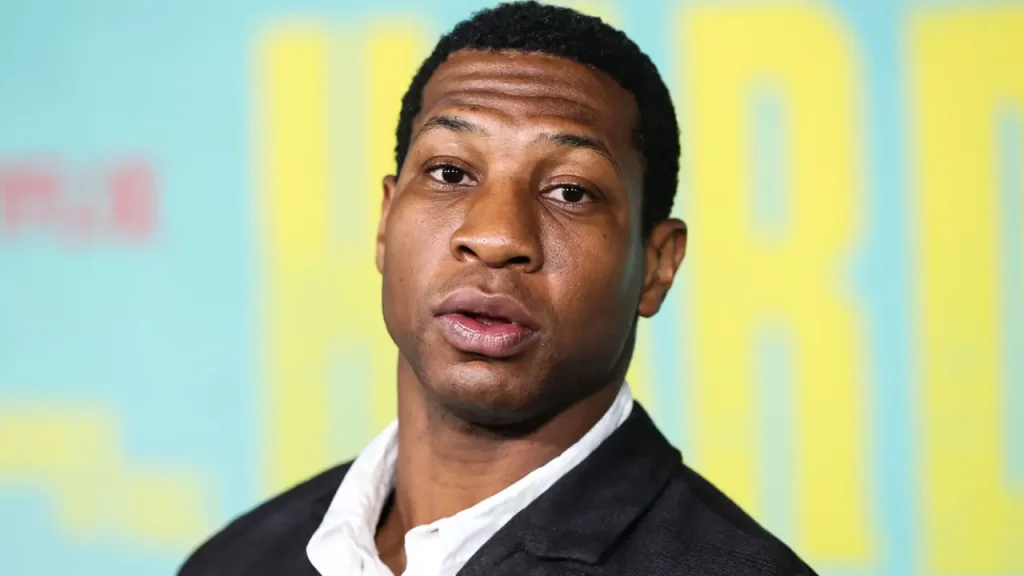 Jonathan Majors guarda in telecamera, sentenza abuso domestico